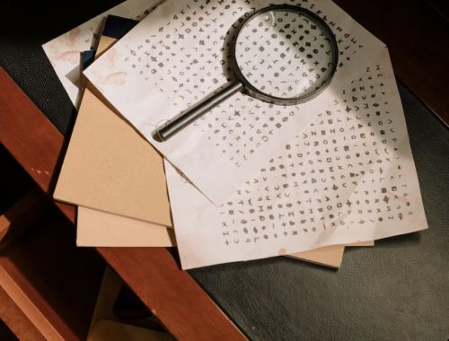 photo of cryptic character codes and magnifying glass on table top